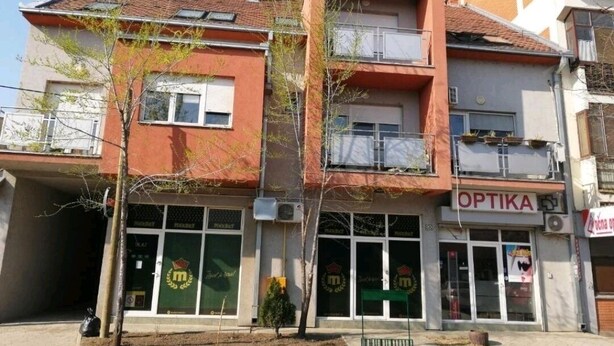 Ein zweistöckiges Gebäude mit einer Schaufensterschaltung mit dem Schriftzug "OPTIKA".