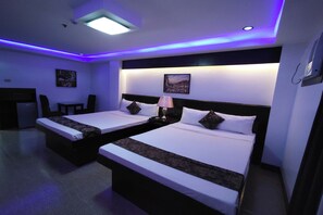 A hotel room with two beds, a desk, and a chair. - Bergamo Hotel Lingayen (Lingayen)