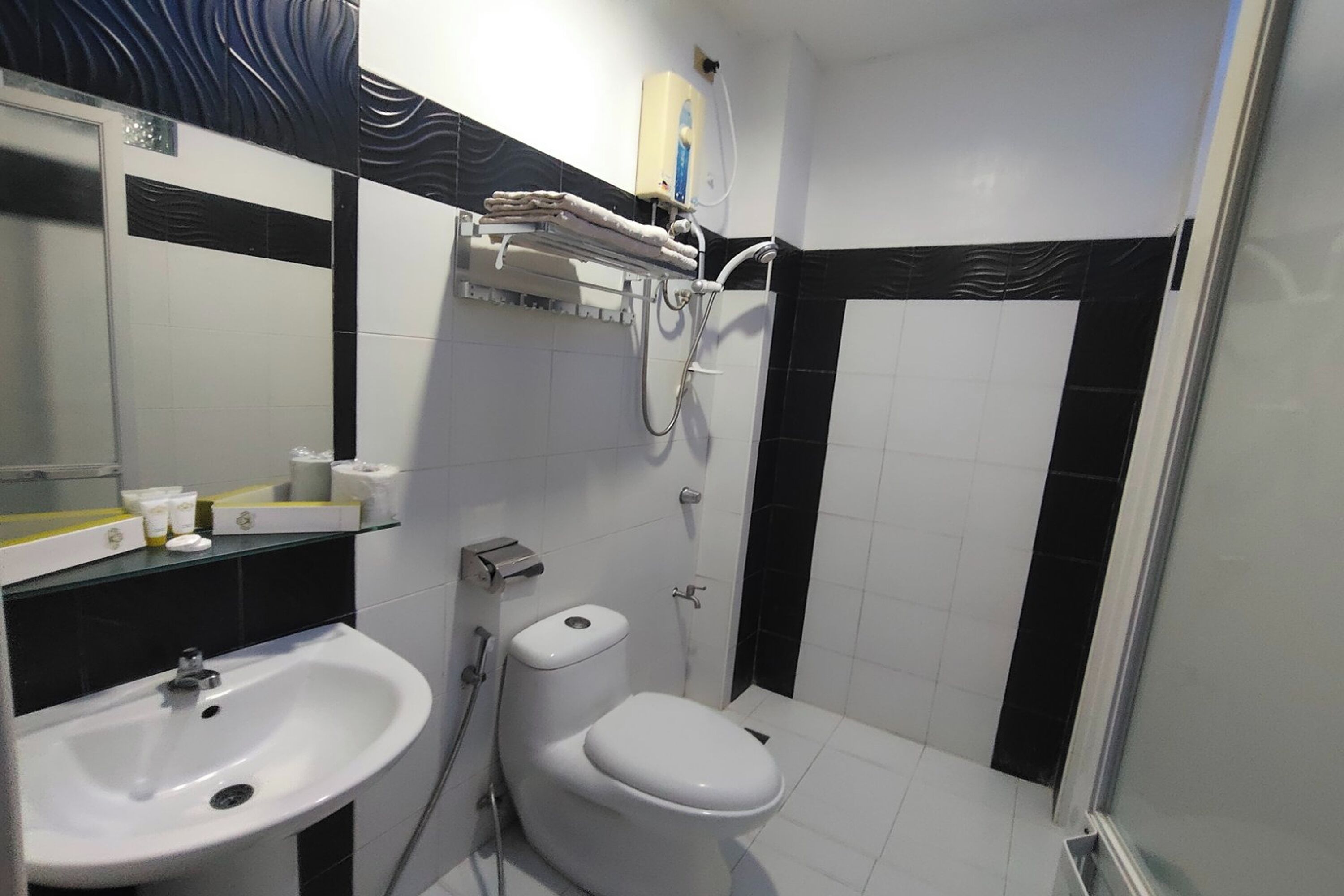 A bathroom with a sink, toilet, and shower.