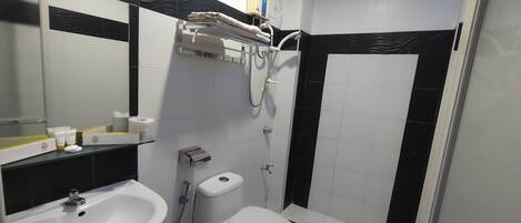 A bathroom with a sink, toilet, and shower.