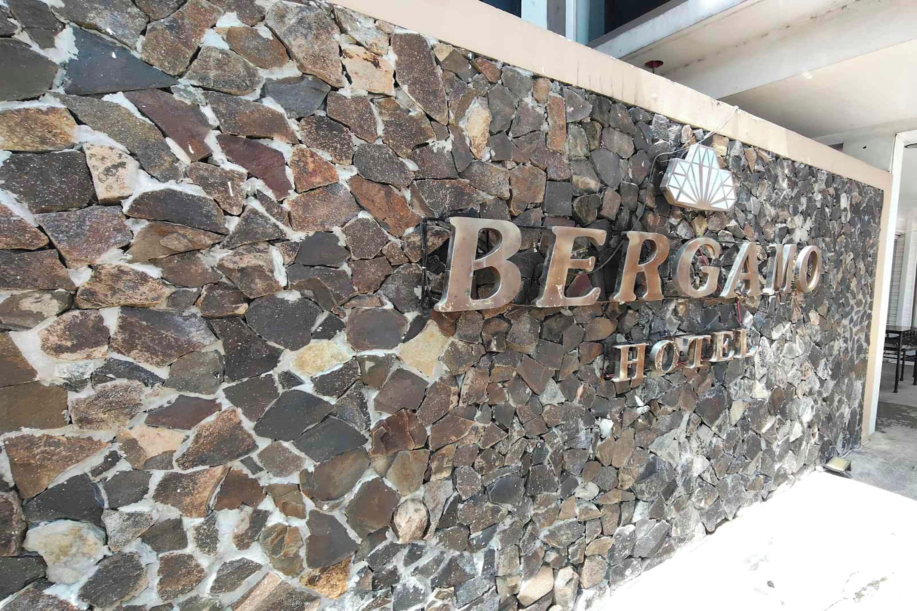 A stone wall with the name "BERGAMO HOTEL" in large letters.