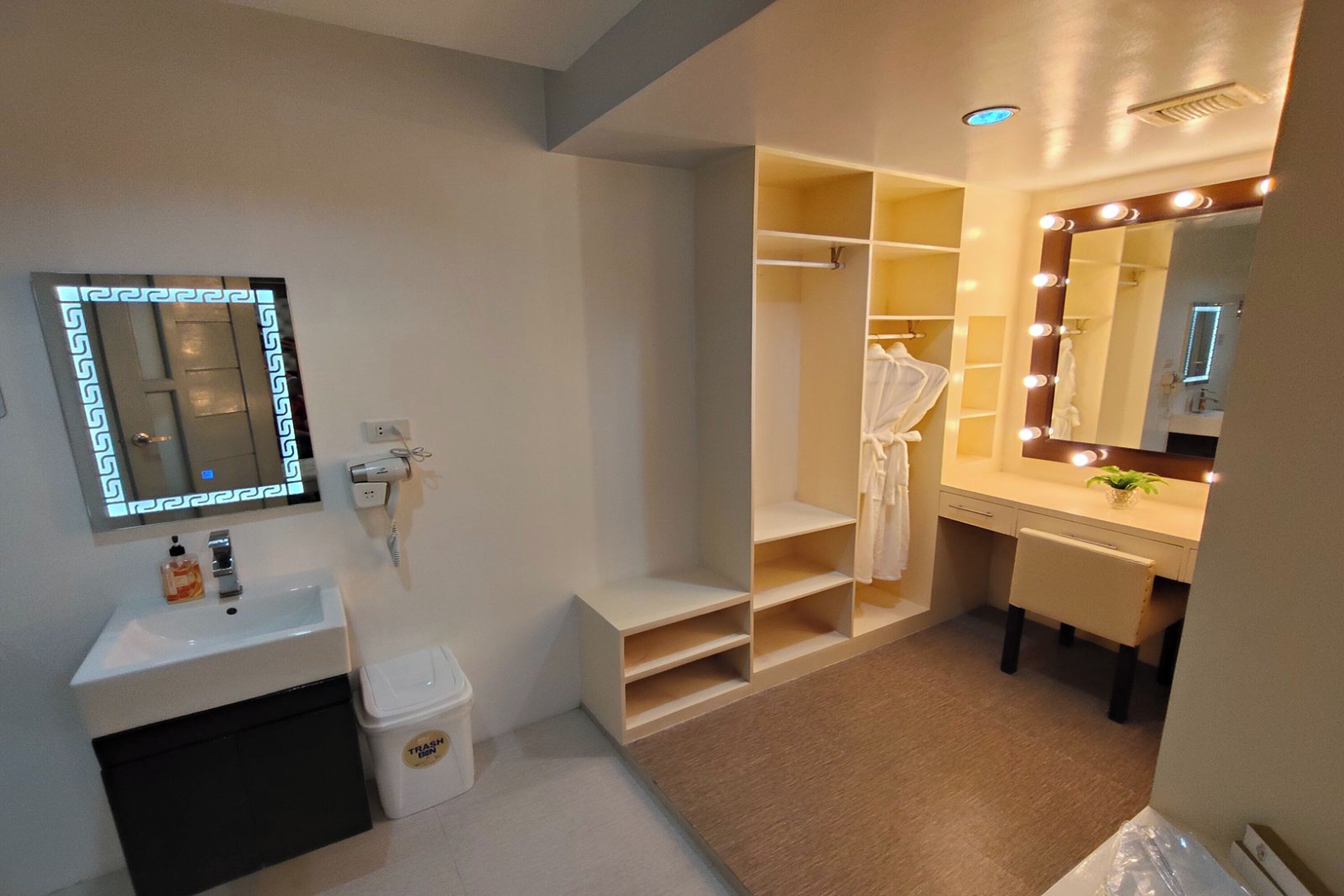 Een moderne badkamer met een wastafel, spiegel en ingebouwde planken.