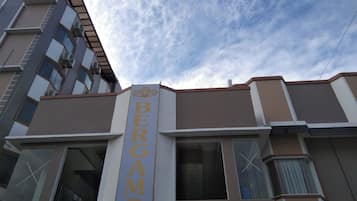 Un edificio con un letrero vertical llamativo que dice "BERGAMO".