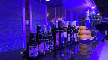 Una zona de bar con una variedad de botellas y un plato de frutas.