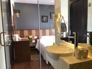 A modern hotel room with a large bed, a vanity with a sink, and a mirror. - Minh Nguyen Hotel (Xuan Huong - Da Lat)