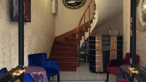A hotel lobby with a grand staircase, a chandelier, and a sign indicating it's the Hotel Takvim Palace in Istanbul. - Taksim Palace İstanbul Hotel (Istanbul)