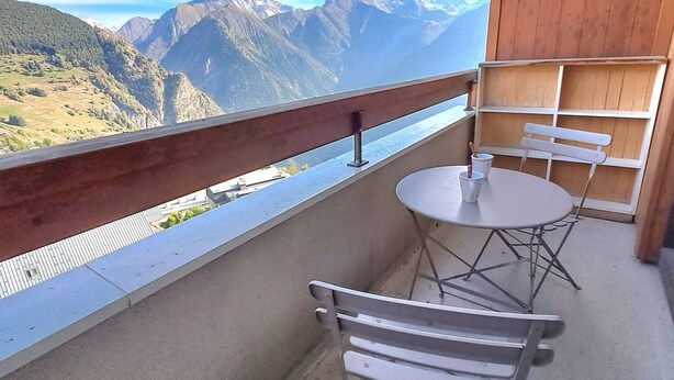 A balcony with a table and chairs, overlooking a mountainous landscape. - Calm T2 apartment, slopes access, private parking (Les Deux Alpes)