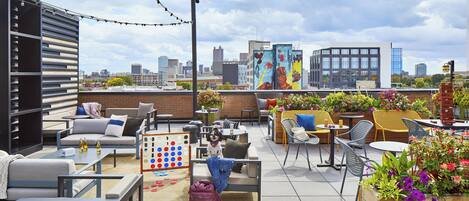 An outdoor patio with seating, tables, and a dog.