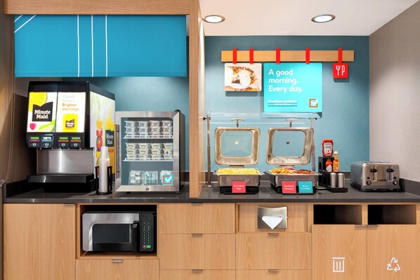 A breakfast bar with a coffee machine, a vending machine, and a toaster. - avid hotels Perry-National Fairground Area by IHG (Perry)