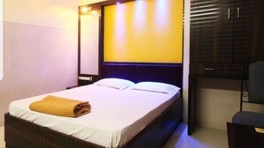 A hotel room with a bed, a nightstand, and a wardrobe. - Hotel Diamond (Mumbai)