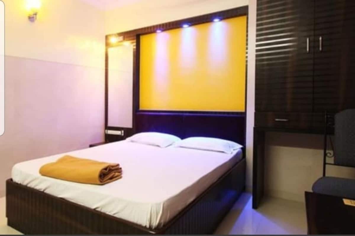 A hotel room with a bed, a nightstand, and a wardrobe.