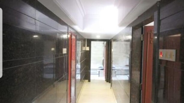 A corridor with marble walls and glass doors, leading to an elevator area. - Hotel Diamond (Mumbai)