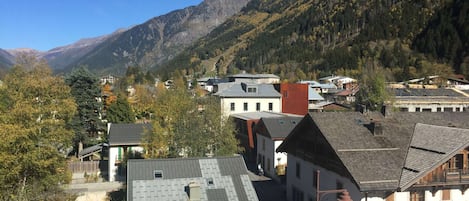 Un pueblo de montaña con arquitectura tradicional, una calle principal y vistas de las montañas circundantes.