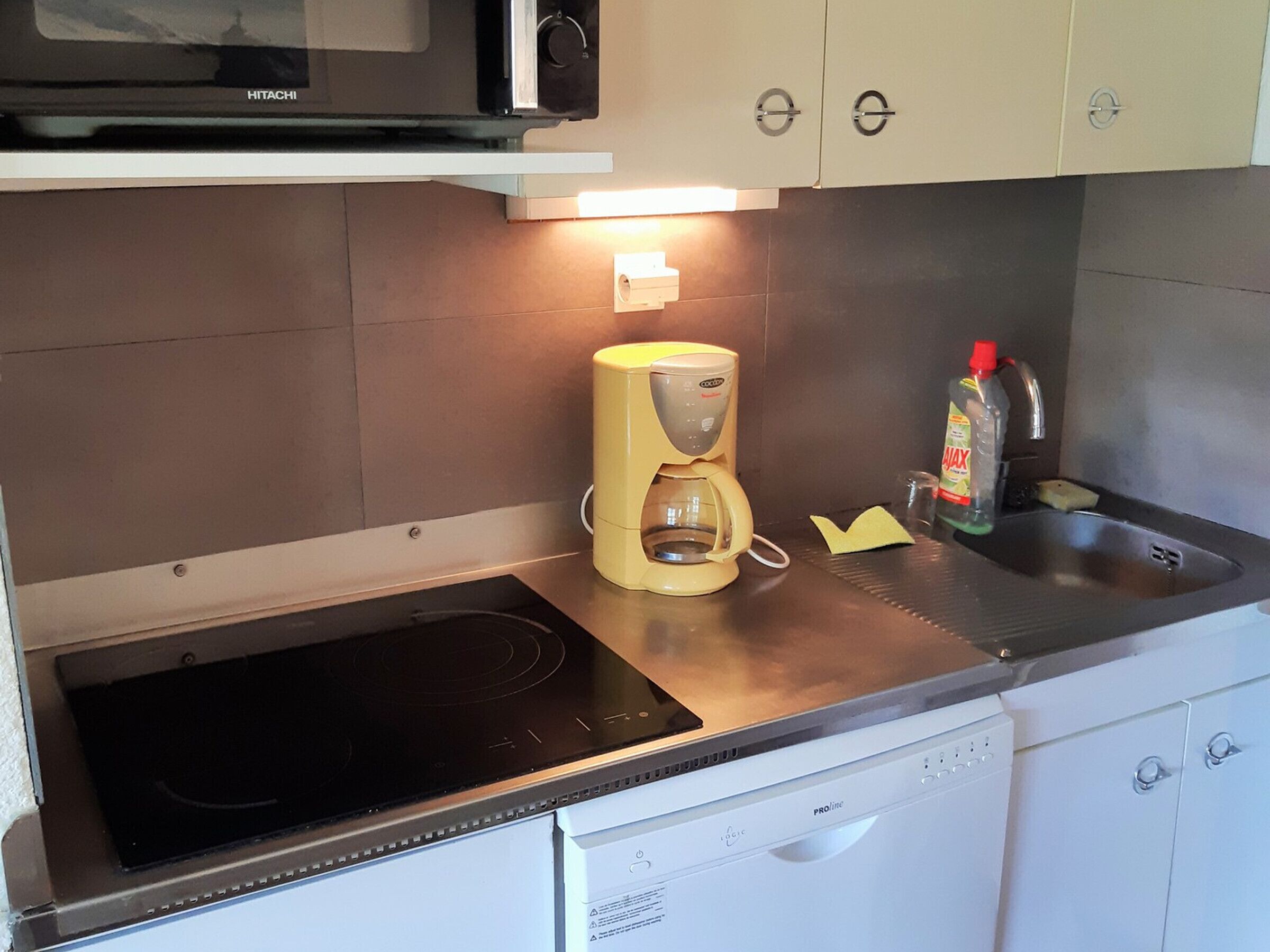 Une cuisine équipée d’un four à micro-ondes, d’une machine à café et d’un lave-vaisselle.