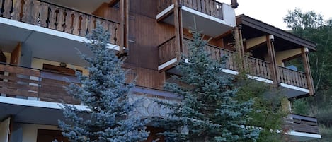 Un immeuble à plusieurs étages, doté de balcons en bois et d’une façade en pierre.