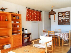 Cozy living space with a dining area, kitchenette, and bookshelf.