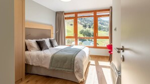 A bedroom with a bed, a window with a view of a landscape, and a door. - 4-bedroom duplex with pool, spa, and parking at Arcs 1800 (Les Arcs 1800)