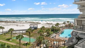 A resort with a beach view, a swimming pool, and a tennis court.