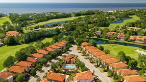 Ein Golfplatz mit Schwimmbad und Wohnhäusern mit roten Ziegeldächern.