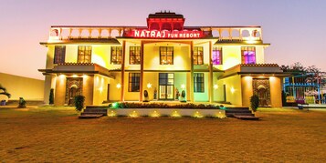 Un edificio de varios pisos con un letrero que dice 'Natra Fun Resort'.
