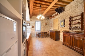 A kitchen with wooden cabinets, a dining table, and a chandelier.