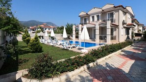 A multi-story residential building with a swimming pool, lounge chairs, and umbrellas. - NEW LISTING!! BEAUTIFUL PRIVATE 5 BEDROOM VILLA RIGHT in CENTRE of DALYAN!!! (Dalyan Mahallesi / Ortaca)