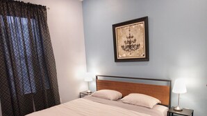 A bedroom with a large bed, two bedside tables with lamps, a ceiling fan, a framed picture on the wall, and a window with curtains. - Modern 3BR/ Close to Encore- Everett #2 (Everett)