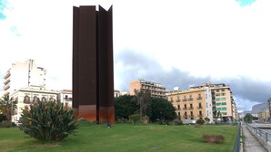 A modern sculpture in a grassy area with buildings in the background. - Il Genio del Porto - Mabbonath b&b (Palermo)