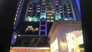 A multi-story hotel with a prominent entrance featuring a stone facade and arched doorways.
