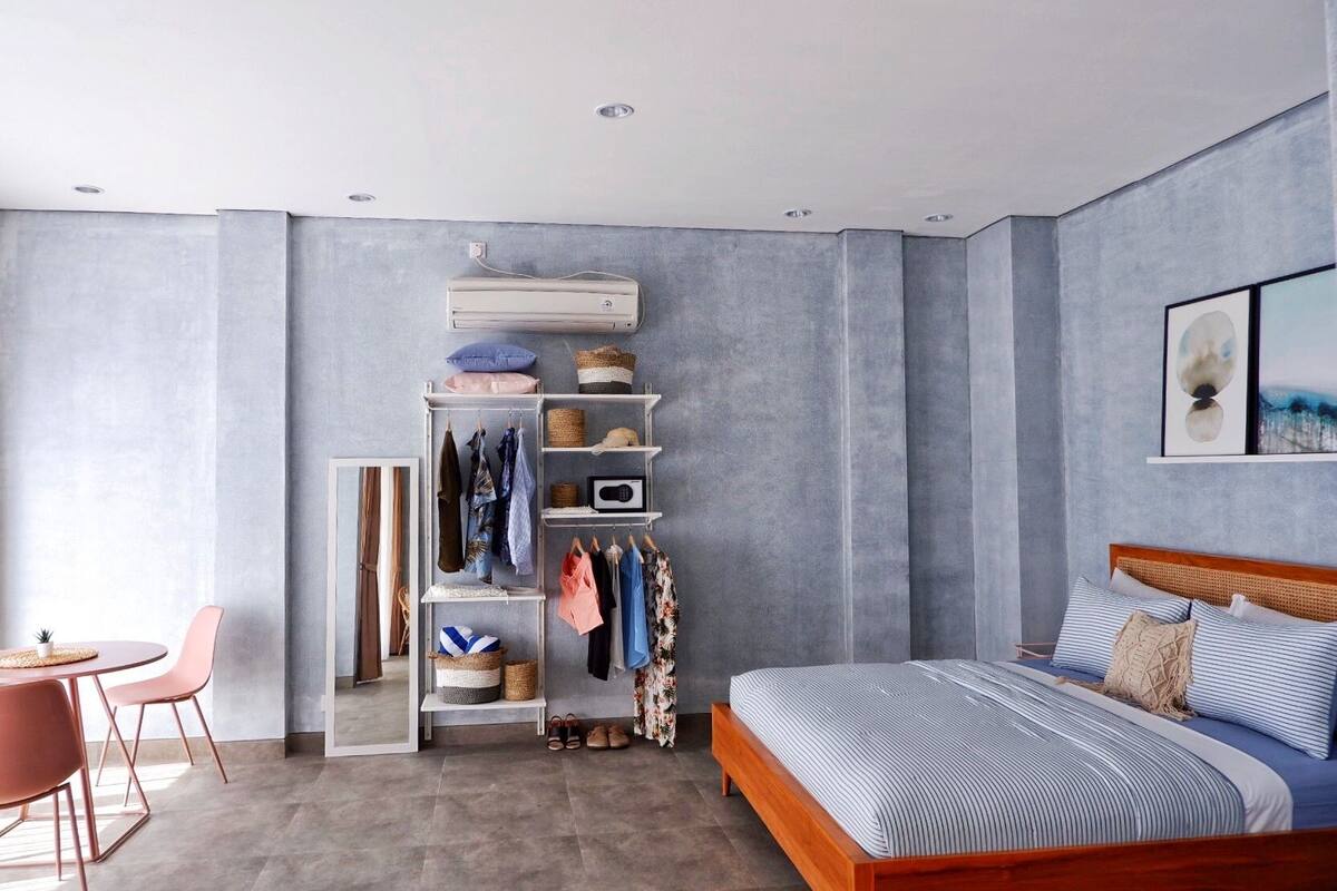 A bedroom with a bed, a wardrobe, a desk, and a chair.