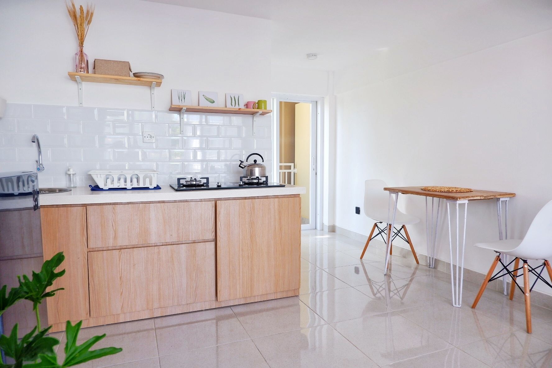 A modern kitchen with wooden cabinets, a gas stove, and a dining area with a table and chairs.