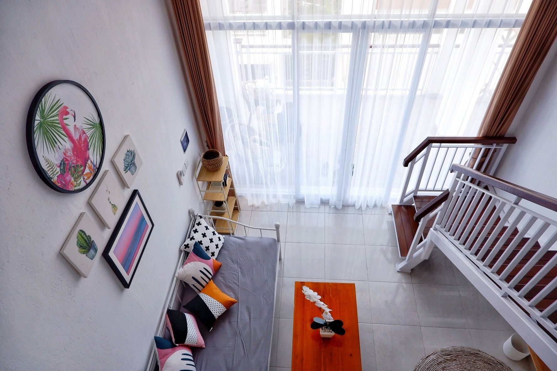 A spacious living area with a sofa, cushions, a coffee table, and a staircase.