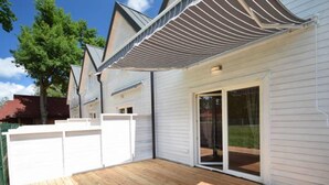 A modern house with a wooden deck, white exterior walls, and a covered patio area. - TuNa (Dziwnów)