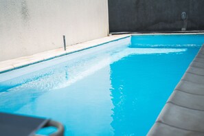 Una piscina al aire libre, una piscina climatizada