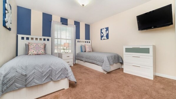 A bedroom with two beds, a TV, and a dresser. - Beautiful townhouse with private pool and water views, 10 minutes from Disney (Kissimmee)
