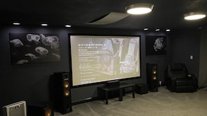 A home theater setup with a large screen, speakers, and a carpeted floor. - Private country setting with large indoor pool (Virden)