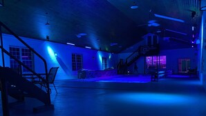 A spacious indoor area with a high ceiling, multiple windows, and a staircase leading to an upper level. - Private country setting with large indoor pool (Virden)