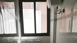 Ett kök med en gasspis, en ugn och ett fönster.