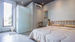 Ein Schlafzimmer mit einem Bett, einem Sessel, einem Schreibtisch und einem großen Fenster.