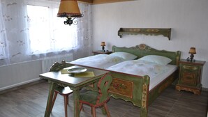Ein Schlafzimmer mit einem hölzernen Bett, einem Tisch und einem Stuhl.