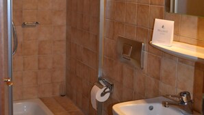 Ein Badezimmer mit Dusche, Toilette, Waschbecken und Spiegel.