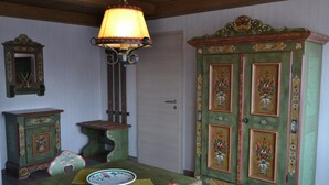 Ein Essbereich mit einem Holztisch, Stühlen und einer Kommode mit floralen Verzierungen.