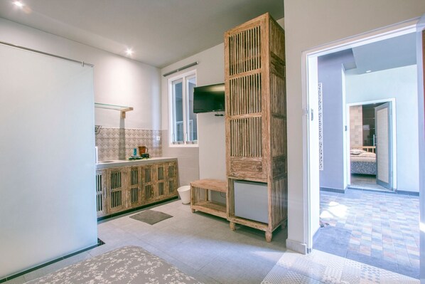 Un baño moderno con tocador de madera, un espejo grande y zona de ducha.