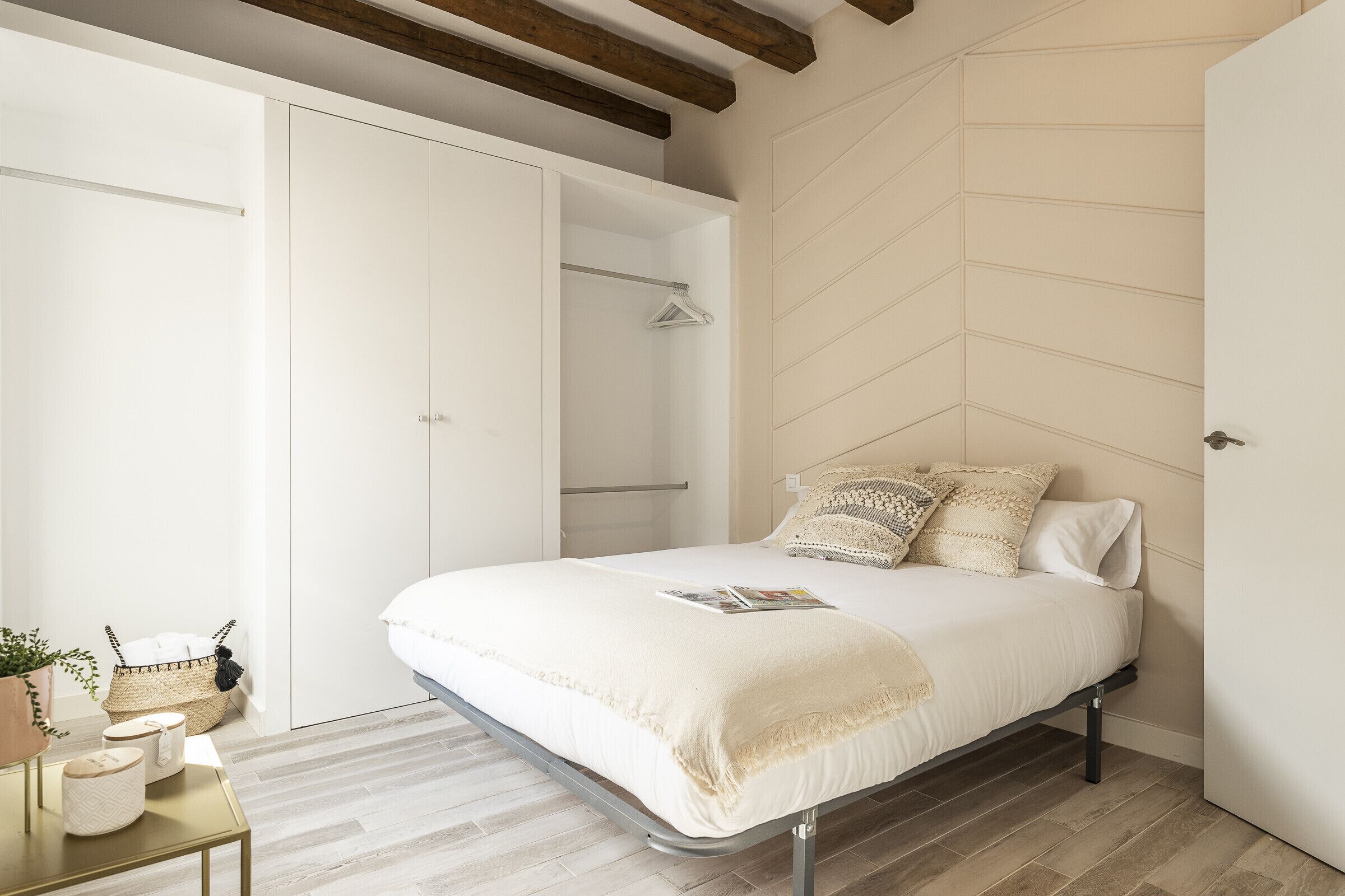 A bedroom with a bed, bedside table, and a wardrobe.