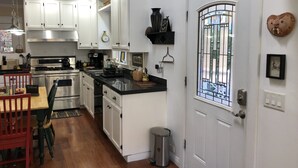 A modern kitchen with white cabinetry, stainless steel appliances, and a black countertop. - 2-story house, all the comforts of home, spectacular space and views!! (Bisbee)
