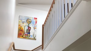 A wooden staircase with white railings and a colorful abstract painting on the wall. - 2-story house, all the comforts of home, spectacular space and views!! (Bisbee)