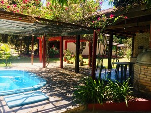 Relax in a serene outdoor space surrounded by lush greenery and a small pool, perfect for a peaceful retreat.