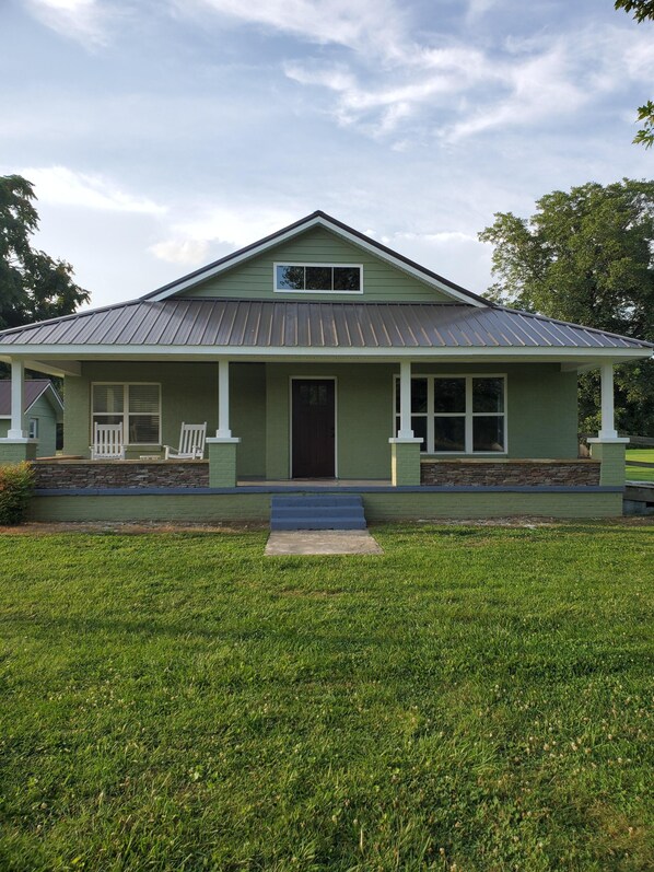 A single-story house with a front porch, a small entryway, and a front yard.