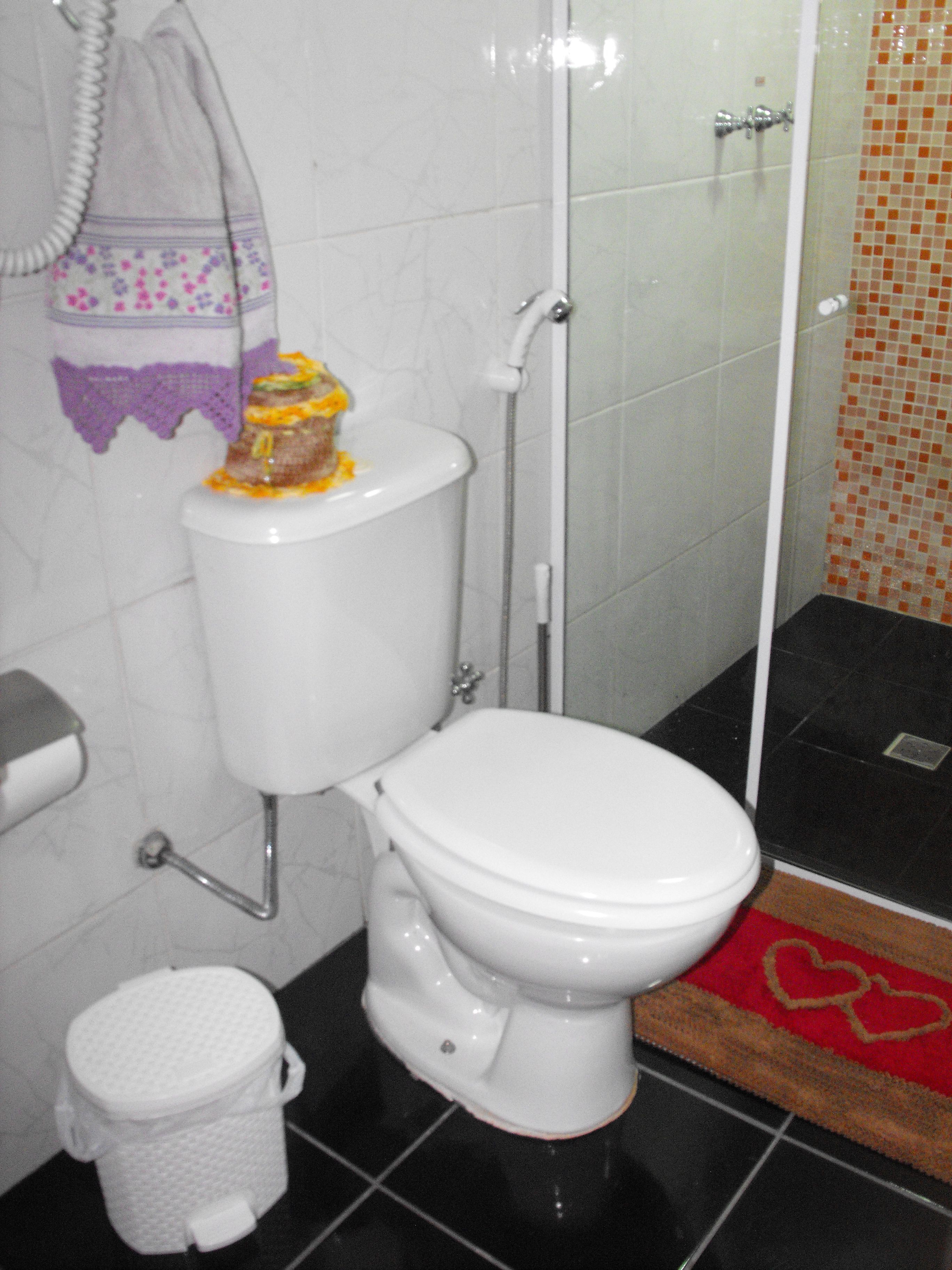 A bathroom with a toilet, a shower, and a bidet.