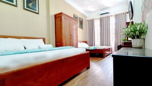 A hotel room with a large bed, a desk, a chair, a wardrobe, and a potted plant. - Forget Me Not Hotel Nha Trang (Nha Trang)